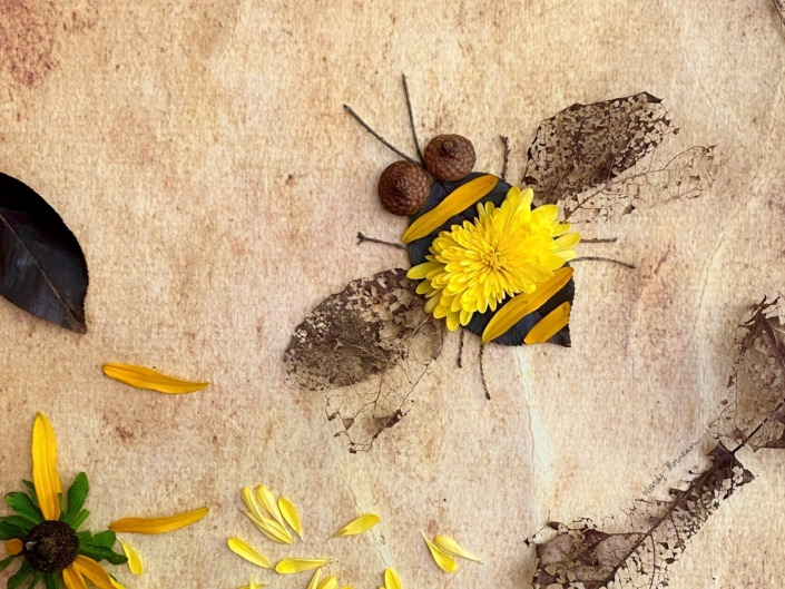 Bee made out of flowers, leaves, and acorns